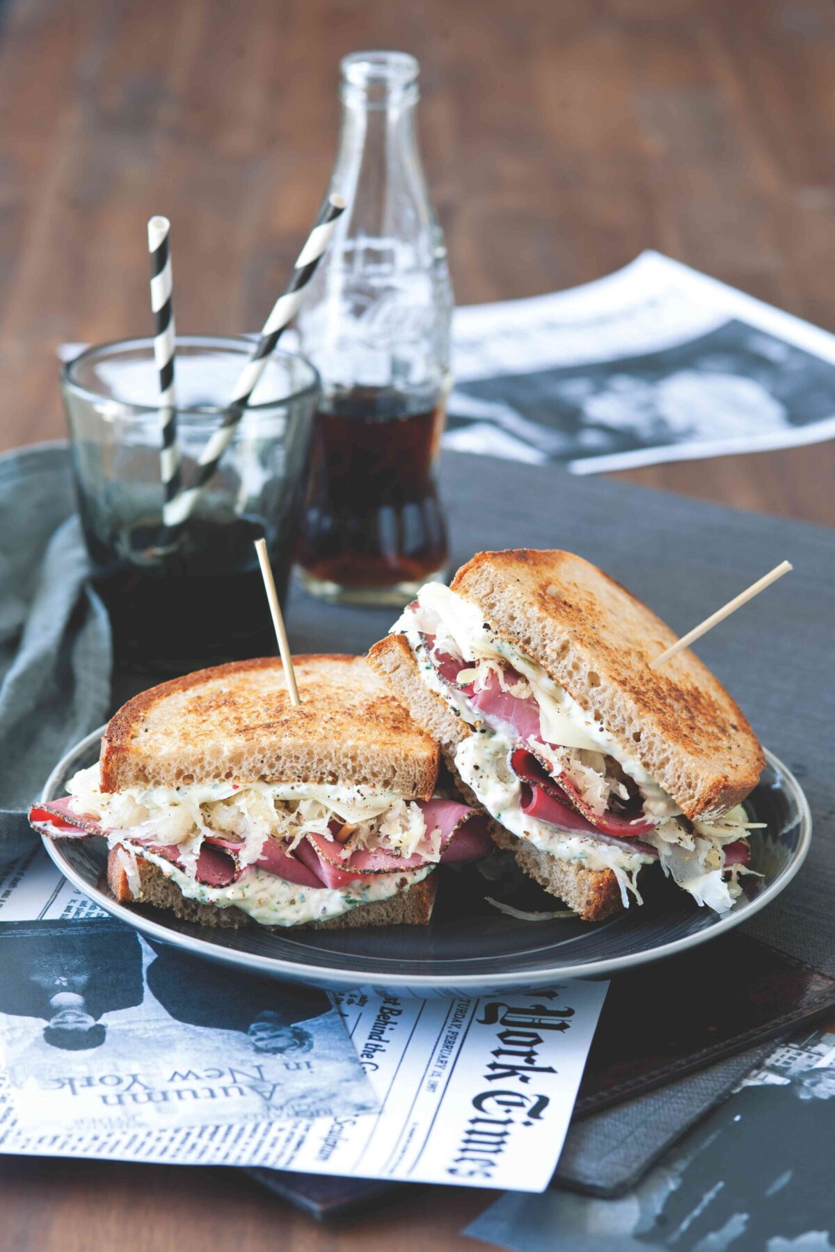 Two halves of a Reuben sandwich stacked on a plate.