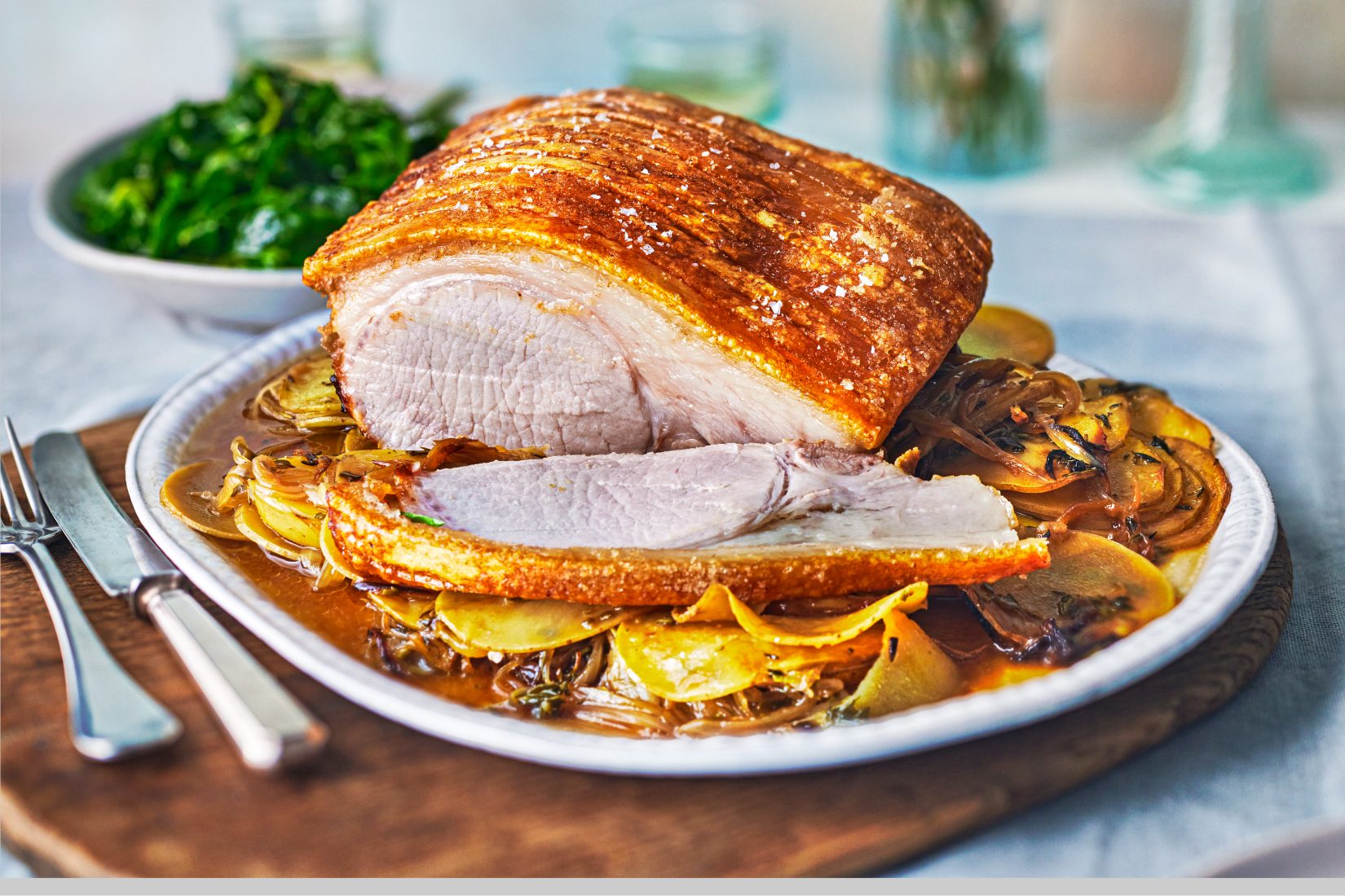 A perfectly roasted pork loin served with golden caramelized onion and garlic potatoes.