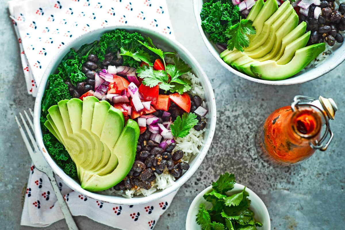 A colorful burrito bowl with chipotle black beans, rice, corn, and avocado.