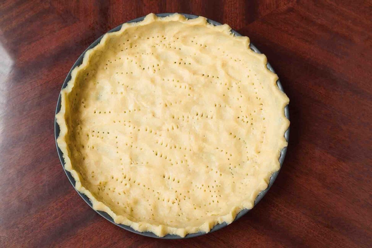 Shortcrust pastry pressed into a tart tin before baking.