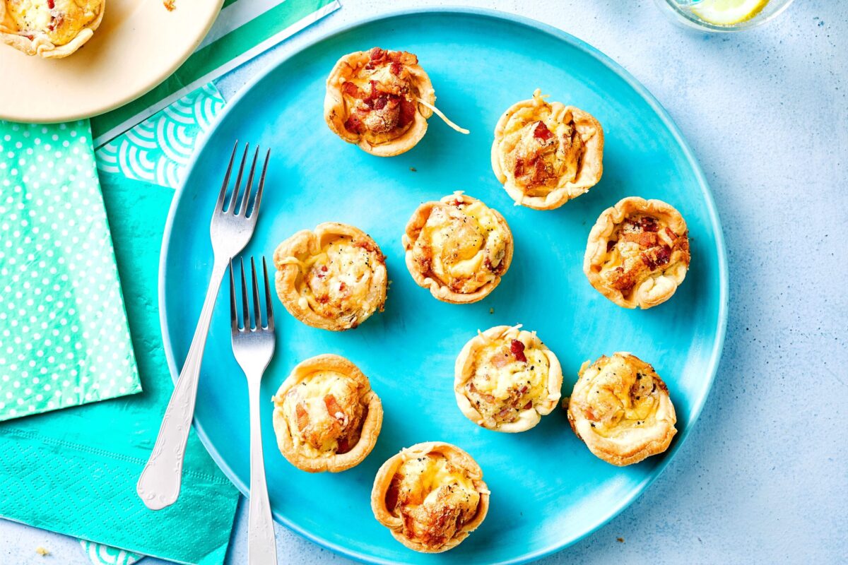 A plate of assorted mini quiches ready to be served.