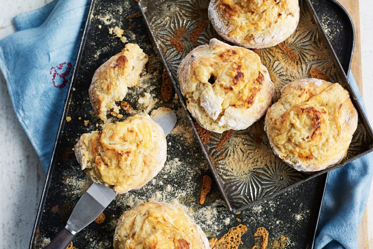 Dark golden scones flavoured with cheese and marmite on a baking tray.