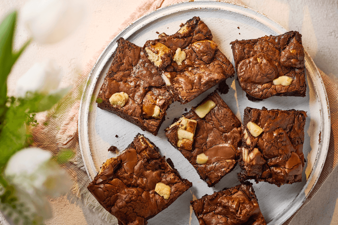 Gooey hot cross bun brownies being pulled apart.
