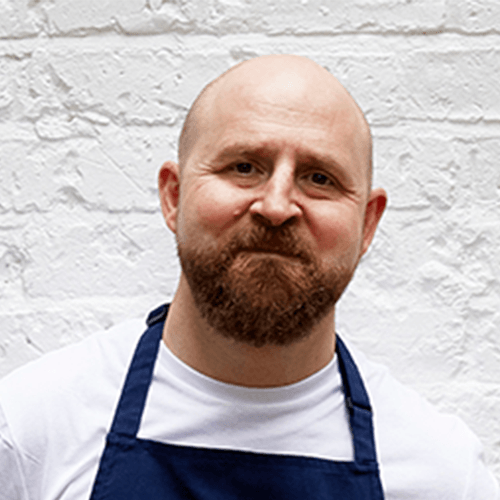 A friendly chef holding a bunch of fresh wild garlic.