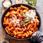 A warm bowl of one-pot chorizo and mozzarella pasta topped with fresh basil.