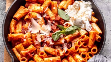 A warm bowl of one-pot chorizo and mozzarella pasta topped with fresh basil.