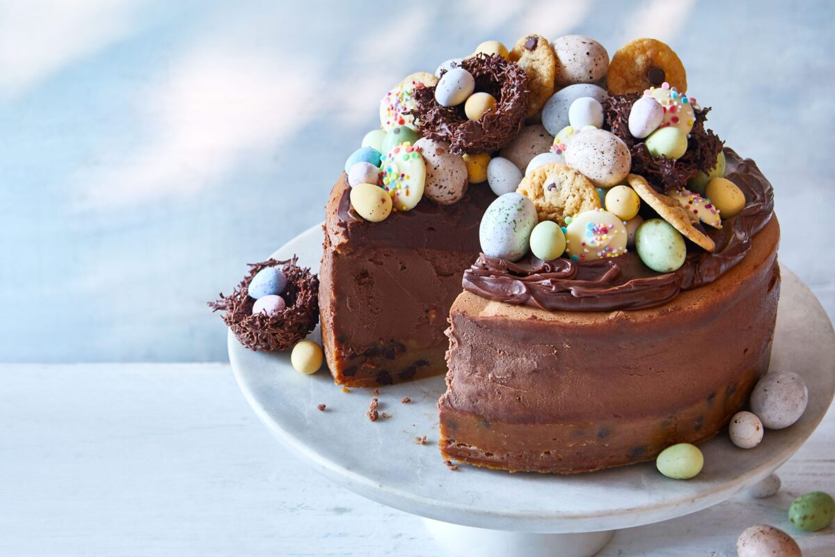 A stunning cookie dough cheesecake topped with chocolate ganache and mini Easter eggs.