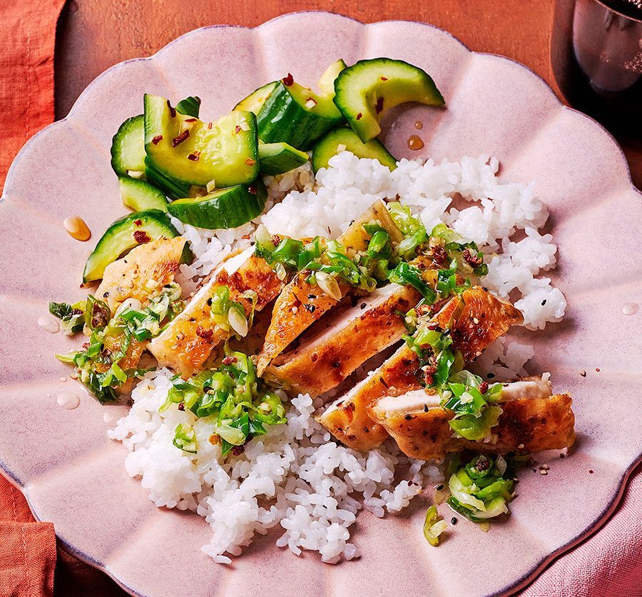 A bowl of crispy fried chicken with rice and fresh spring onions