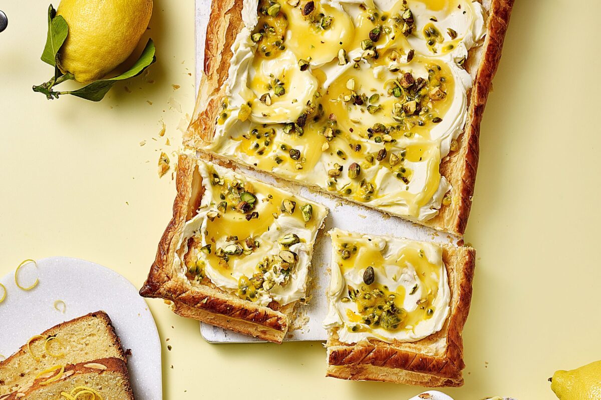A beautiful rectangular lemon and passion fruit tart on a puff pastry base.