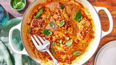 A skillet of creamy Marry Me Chicken garnished with fresh basil.