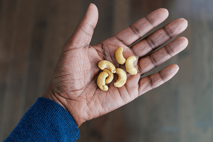 Mindful portion of nuts A hand holding a small portion of healthy nuts.