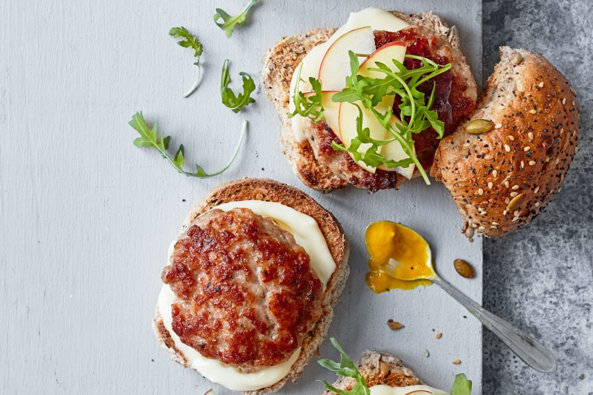Pork and apple burgers served in buns with a side of salad.
