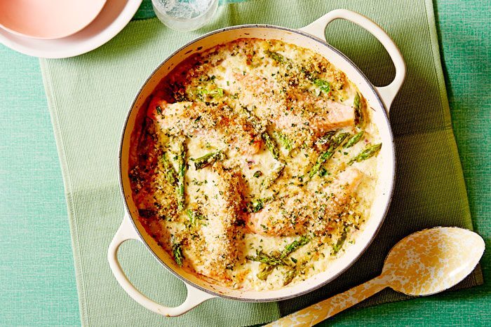 Creamy salmon and asparagus gratin in a white baking dish