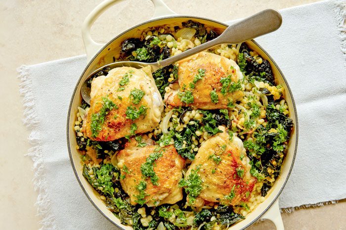 Garlicky chicken thighs served with giant couscous and vegetables