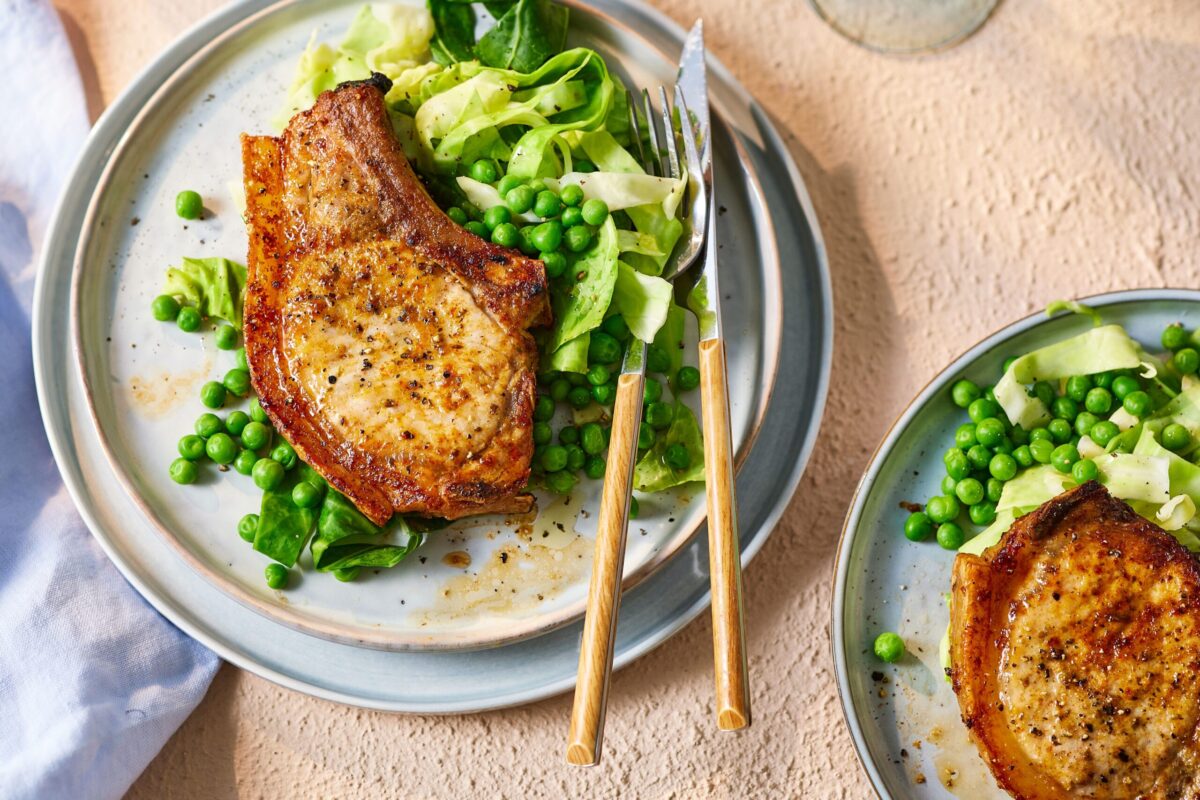 Air fryer pork chops served on a plate with green vegetables