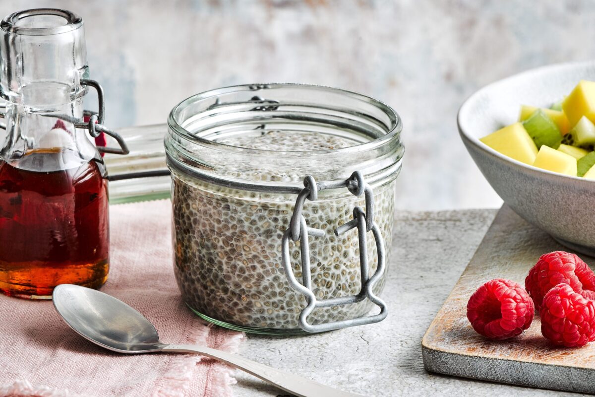 Creamy chia seed pudding in a glass jar topped with fresh berries.