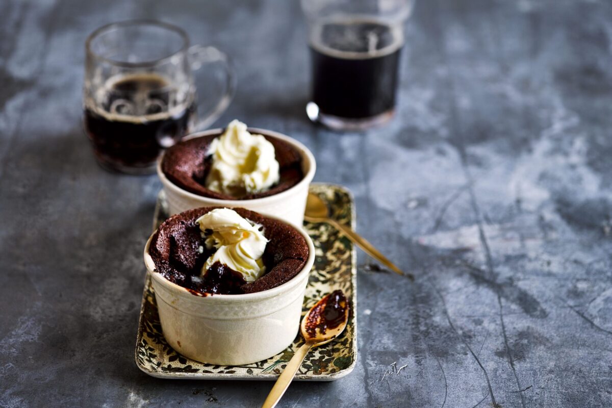 Individual Guinness chocolate puddings with cream on top.