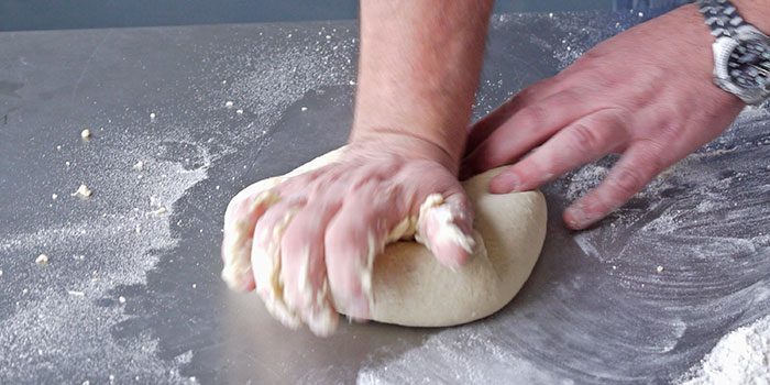 Stretching the dough to test for elasticity.