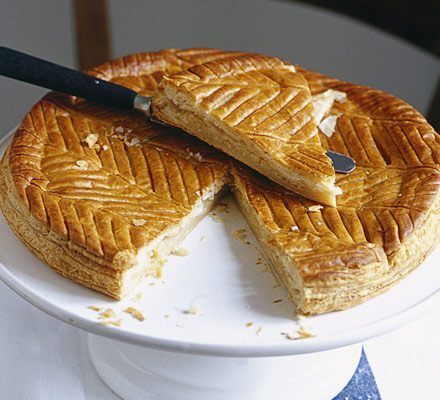 A golden brown Galette des Rois on a platter.