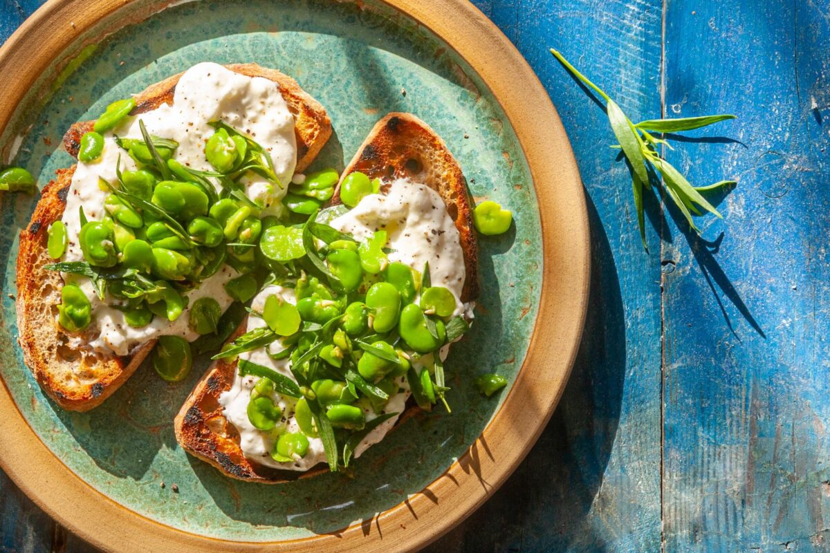 Cooked broad beans served on toast with ricotta cheese