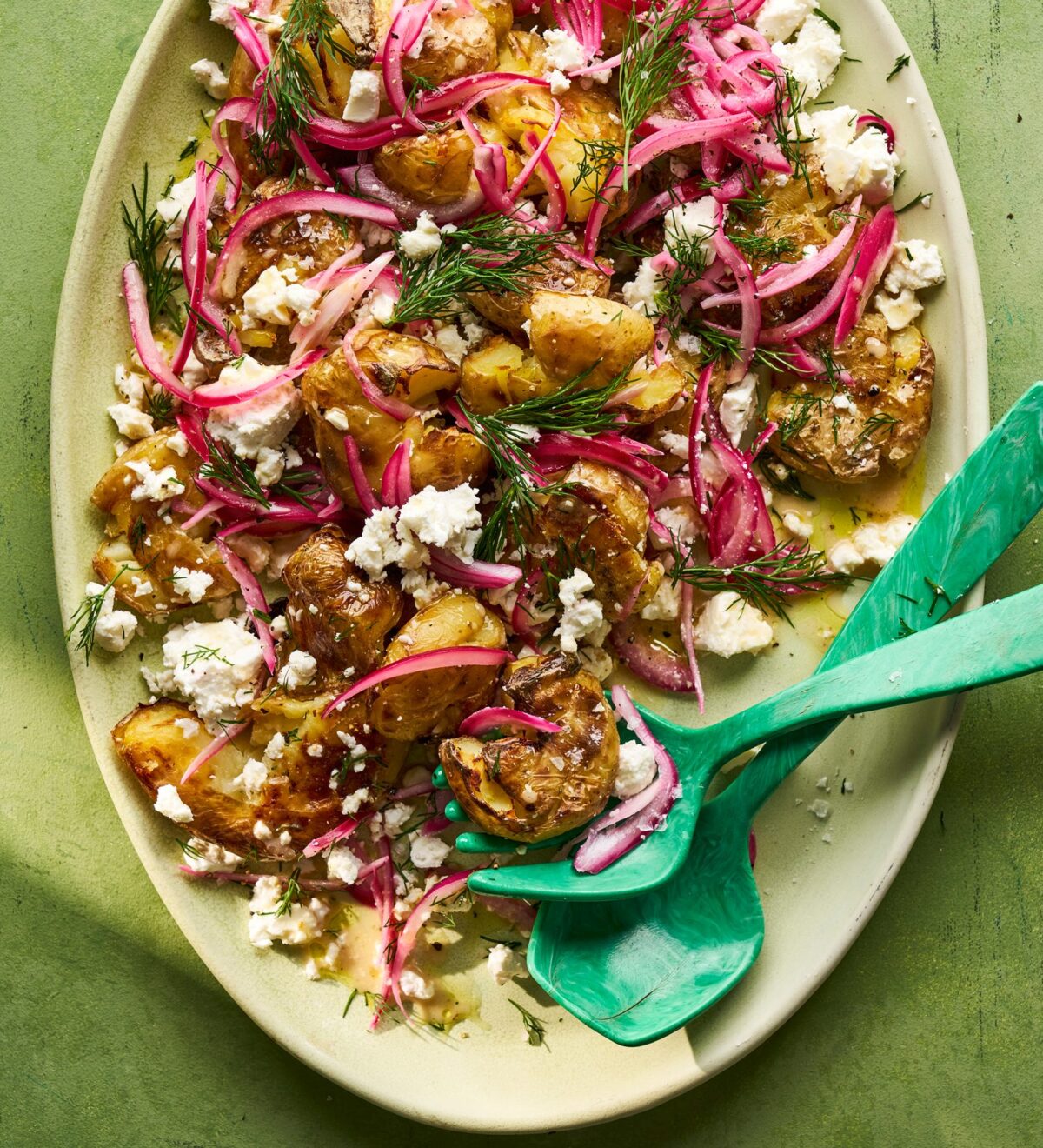Smashed potato, dill, feta & pickled red onion salad in a serving bowl
