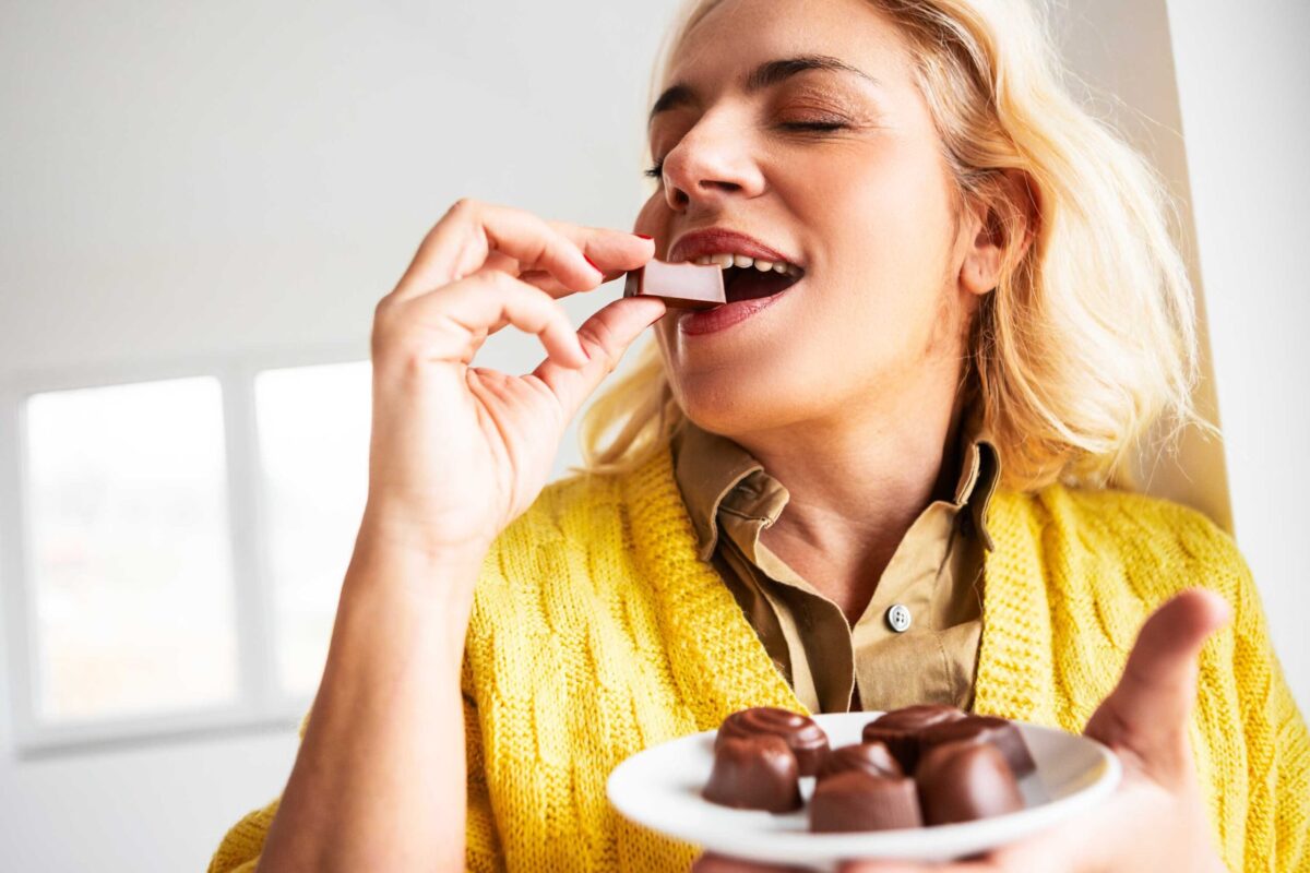 Woman happily eating a piece of chocolate