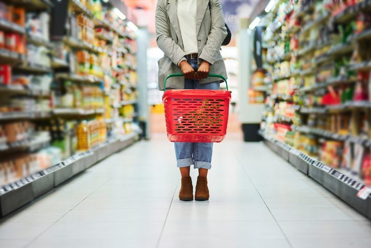 A person shopping for healthy ingredients in a supermarket aisle.