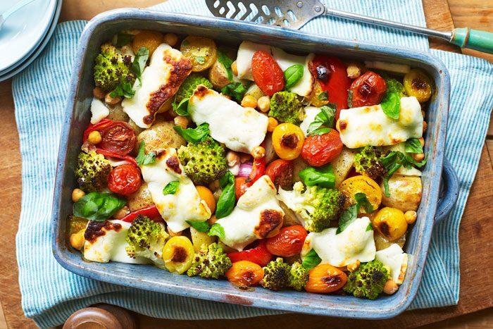 A colorful halloumi and vegetable traybake in a baking dish