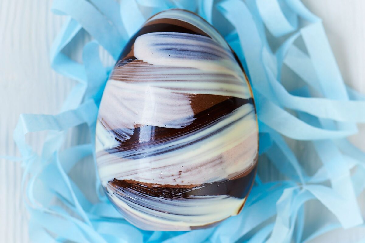A perfectly tempered homemade chocolate Easter egg with a glossy finish.