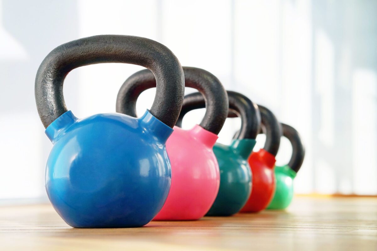 A collection of kettlebells on a gym floor