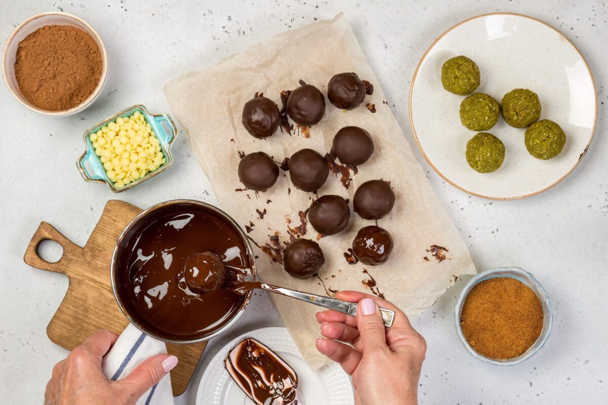 Hands rolling chocolate truffles, a perfect use for tempered chocolate.