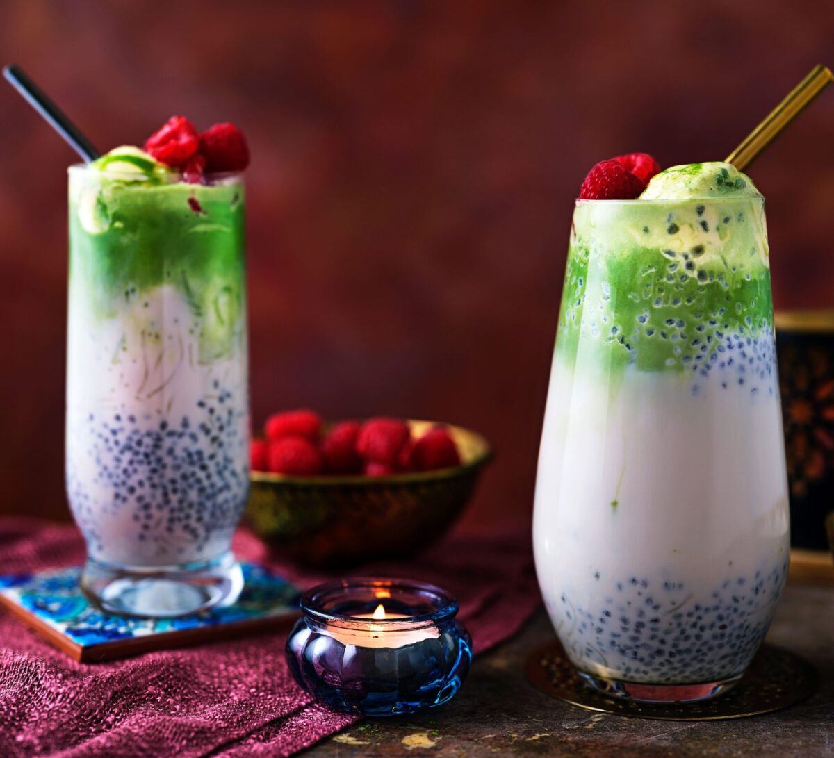 Two tall glasses of layered Matcha Falooda with straws.