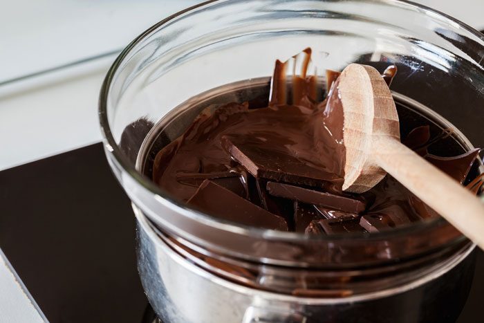 Melting chocolate in a glass bowl over a saucepan of water.