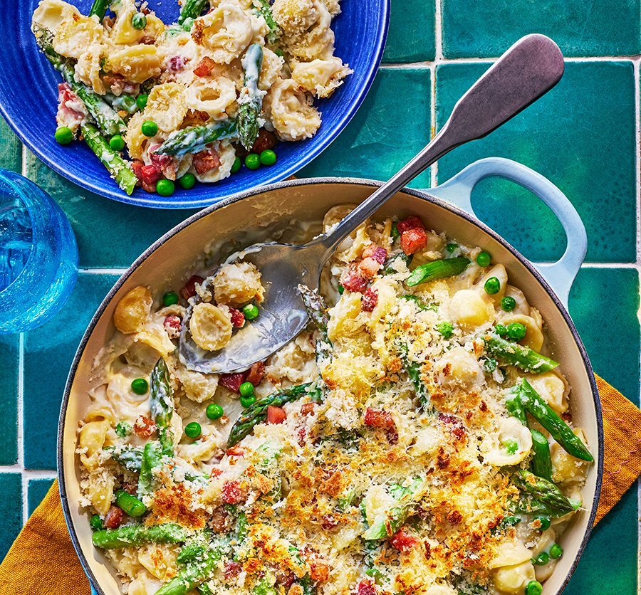 A comforting pasta bake with pancetta, peas, and asparagus