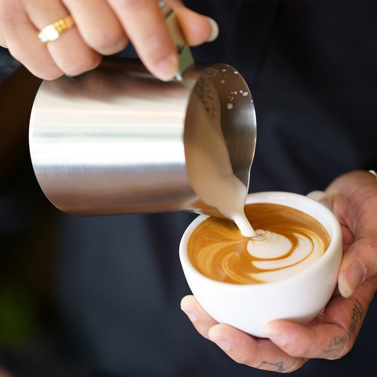 Pouring beautiful latte art into a cup of coffee.