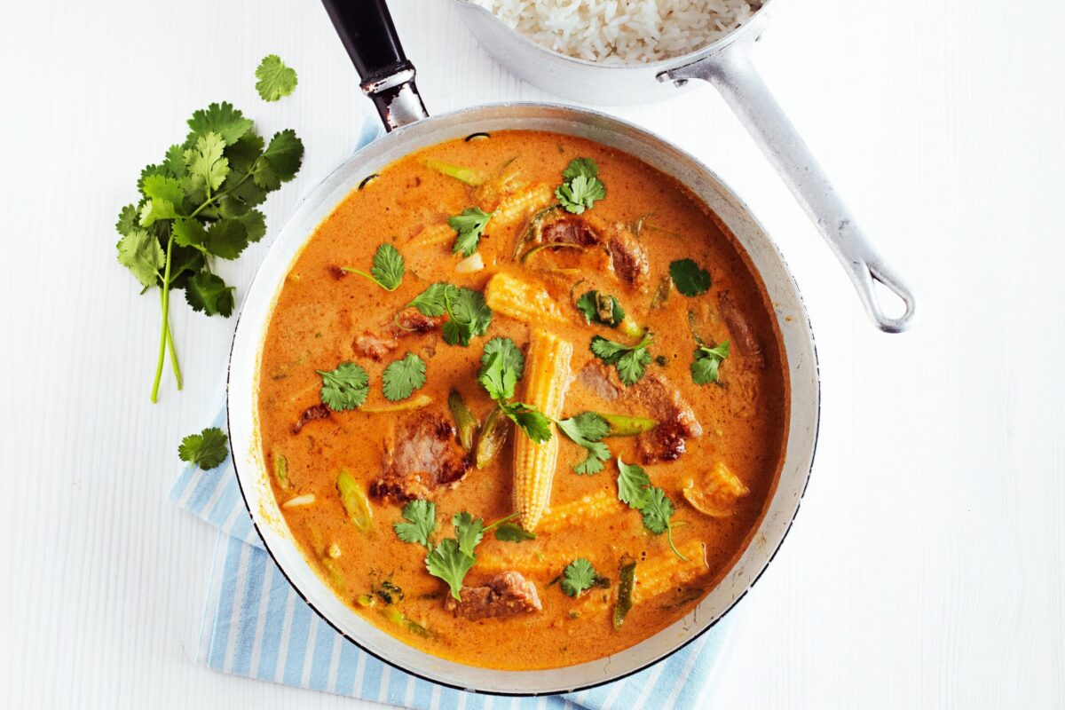 A pan of Thai pork and peanut curry with fresh coriander