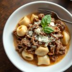 Olive Garden braised beef tortellini recipe in a white bowl with tender shredded beef cheese tortellini and parmesan